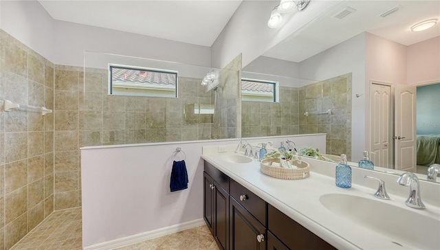 bathroom featuring vanity, a healthy amount of sunlight, and tiled shower