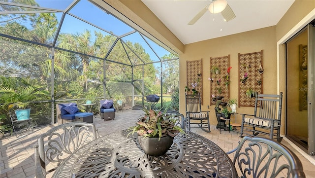 view of patio with ceiling fan, grilling area, and glass enclosure