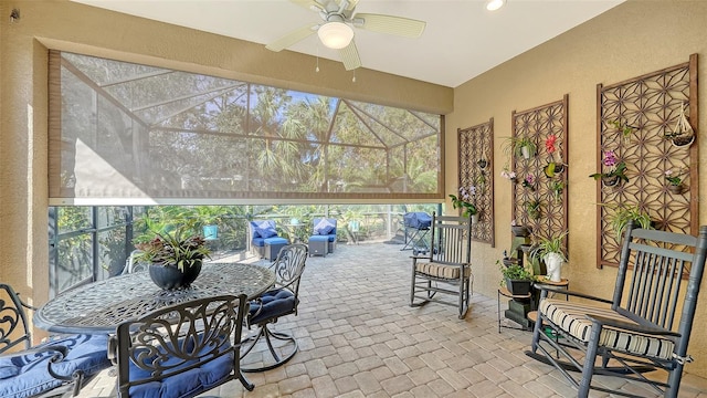 view of patio with glass enclosure and ceiling fan