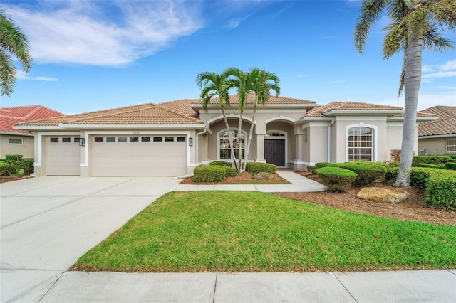 mediterranean / spanish-style house featuring a garage and a front lawn