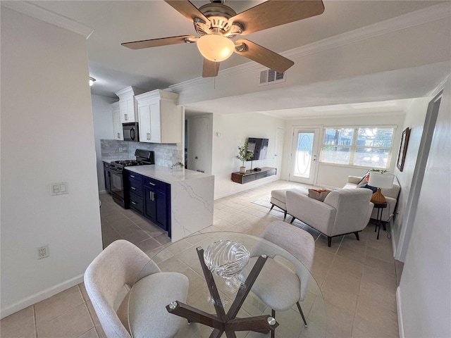 kitchen with tasteful backsplash, black appliances, light tile patterned flooring, white cabinets, and blue cabinetry