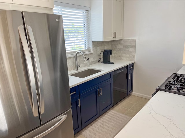 kitchen featuring dishwasher, sink, blue cabinets, stainless steel fridge, and white cabinets