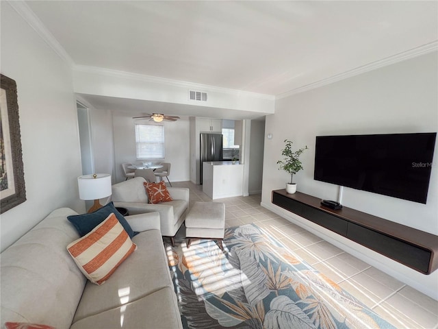 tiled living room with ornamental molding and ceiling fan