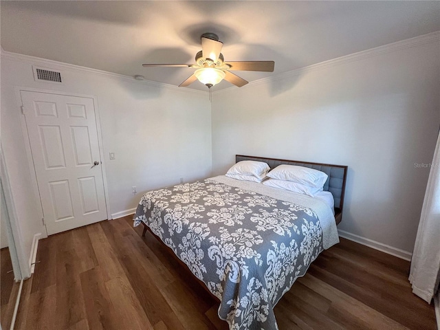 bedroom featuring ornamental molding, dark wood-type flooring, and ceiling fan