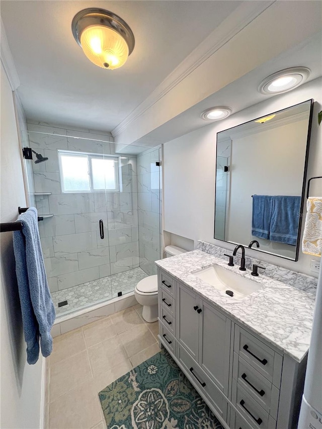 bathroom with tile patterned floors, toilet, a shower with shower door, ornamental molding, and vanity