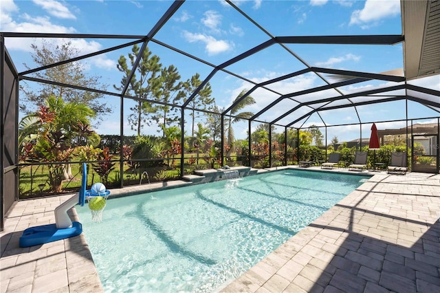 view of pool with a patio, pool water feature, and glass enclosure