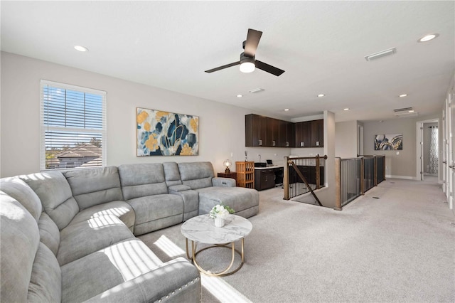 carpeted living room with ceiling fan