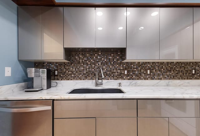 kitchen featuring dishwasher, light stone counters, decorative backsplash, and sink