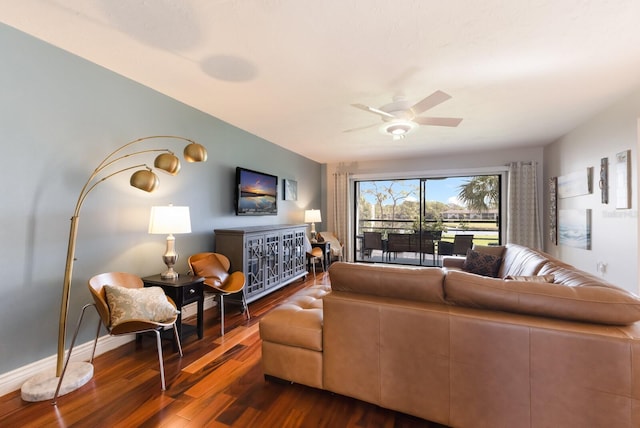 living room featuring ceiling fan and dark hardwood / wood-style floors