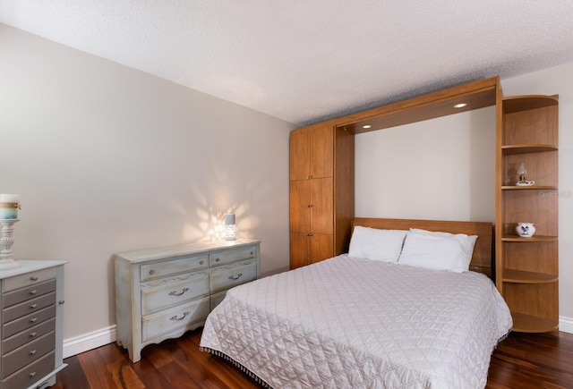 bedroom with a textured ceiling and dark wood-type flooring