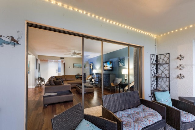 living room featuring ceiling fan and dark wood-type flooring