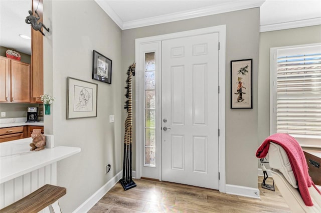 entryway with ornamental molding and light hardwood / wood-style floors