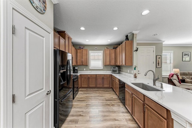 kitchen featuring light hardwood / wood-style flooring, ornamental molding, sink, black appliances, and a textured ceiling