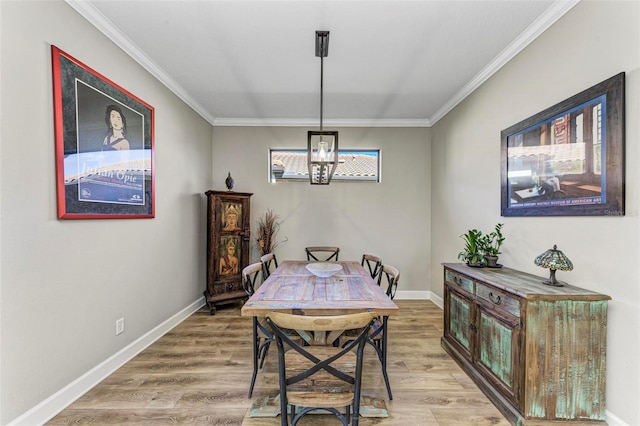 dining space featuring ornamental molding, light hardwood / wood-style flooring, and a chandelier