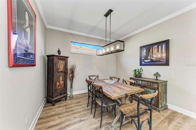 dining area featuring a notable chandelier, ornamental molding, and hardwood / wood-style floors