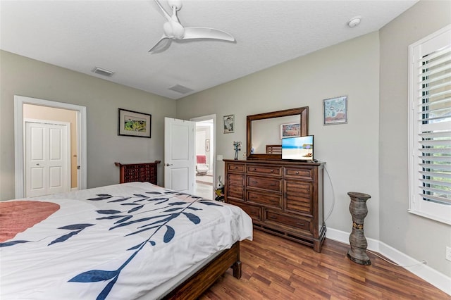 bedroom featuring dark wood-type flooring, ceiling fan, and a textured ceiling