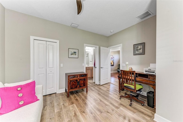 home office featuring a textured ceiling and light wood-type flooring