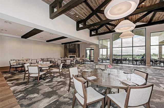 dining area featuring beam ceiling, high vaulted ceiling, and wood-type flooring