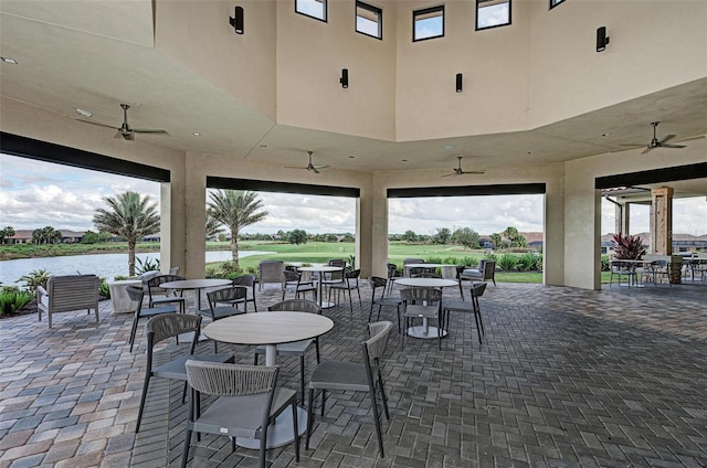 view of patio featuring a water view and ceiling fan