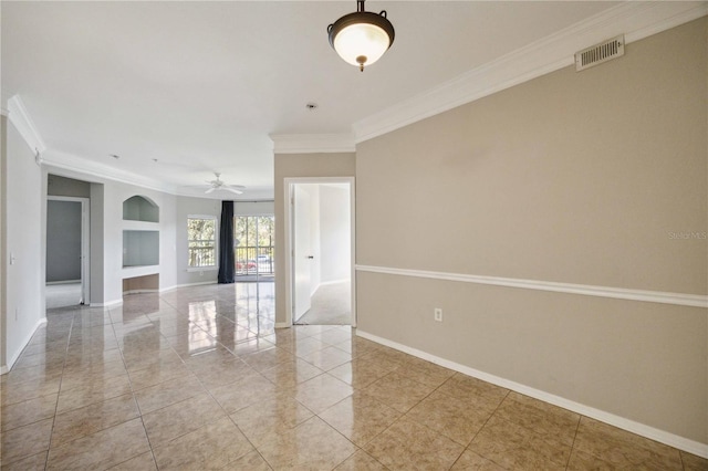 tiled empty room with ornamental molding, built in shelves, and ceiling fan