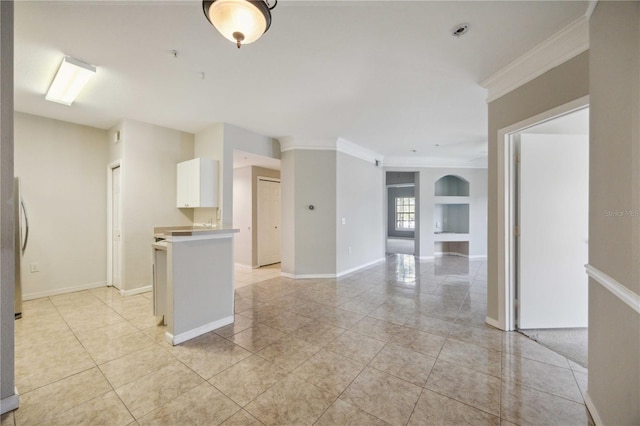 kitchen featuring white cabinetry, crown molding, stainless steel refrigerator, and light tile patterned floors