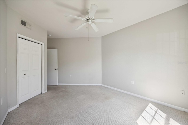 unfurnished bedroom featuring light colored carpet, a closet, and ceiling fan