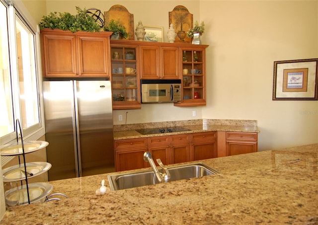 kitchen with light stone counters, appliances with stainless steel finishes, and sink