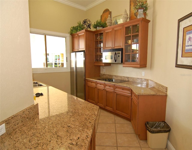 kitchen featuring light tile patterned flooring, crown molding, stainless steel appliances, and light stone counters