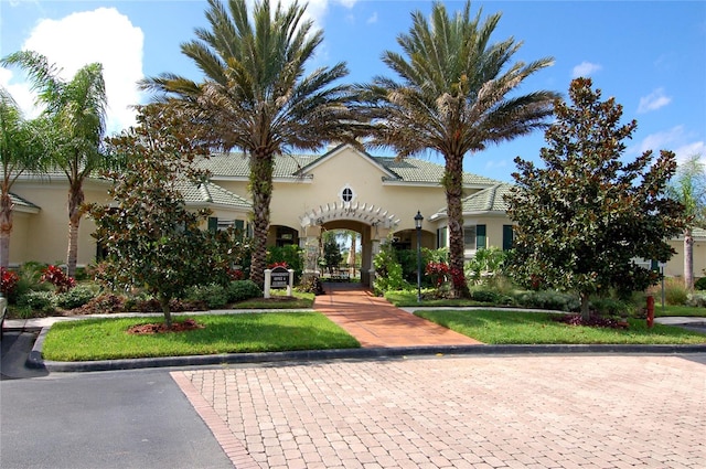 mediterranean / spanish home featuring a front lawn