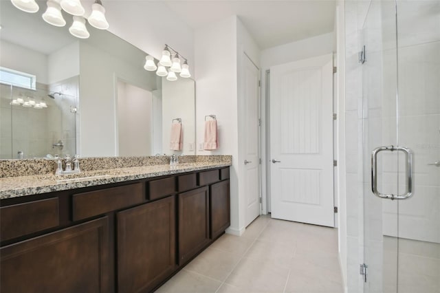 bathroom featuring a shower with door, vanity, and tile patterned flooring