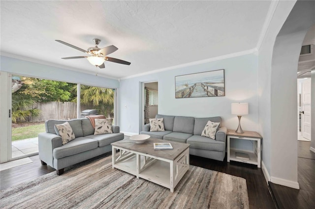 living room featuring ornamental molding, dark hardwood / wood-style floors, a textured ceiling, and ceiling fan