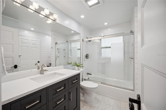 full bathroom with vanity, shower / bath combination with glass door, and toilet