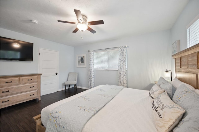 bedroom with ceiling fan, multiple windows, and dark hardwood / wood-style floors