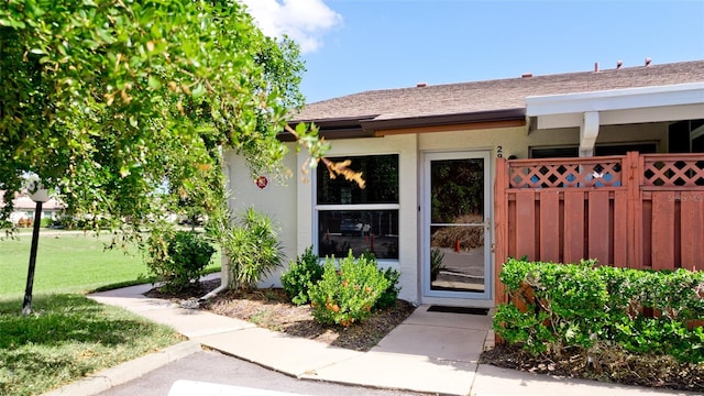 property entrance featuring a lawn