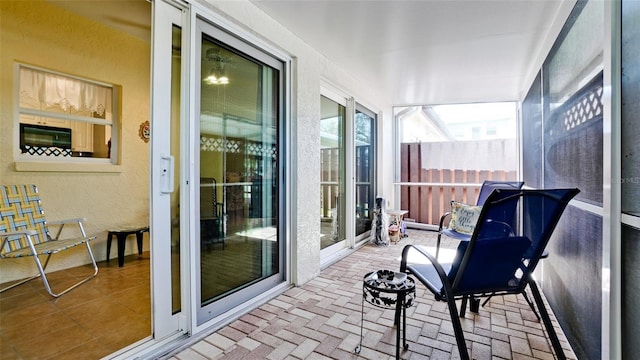 sunroom / solarium featuring a textured wall and brick floor