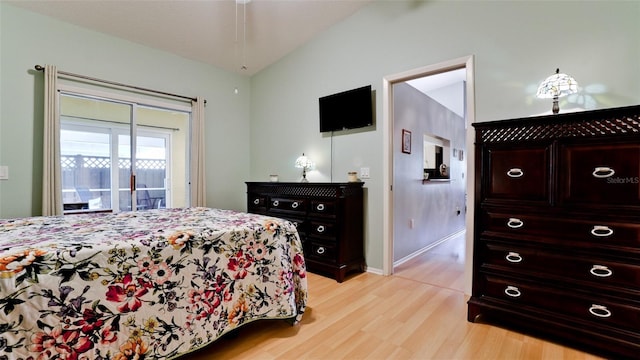 bedroom featuring baseboards, access to outside, lofted ceiling, and light wood finished floors