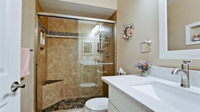 full bathroom with toilet, a stall shower, and vanity