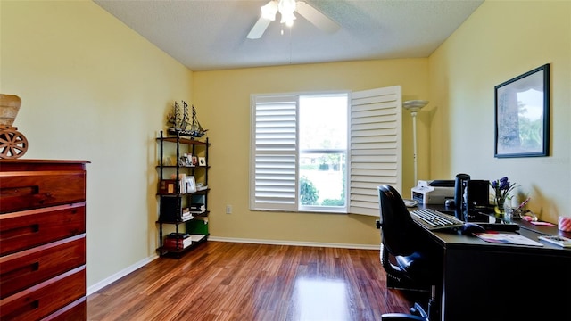 home office featuring dark wood-type flooring, a textured ceiling, and ceiling fan