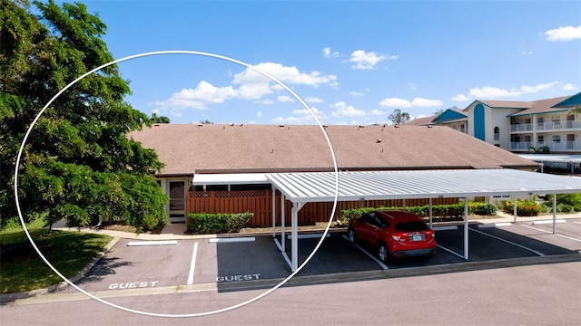 covered parking lot featuring fence