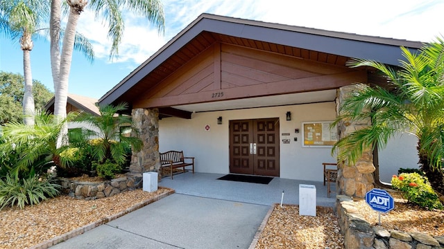 view of exterior entry featuring stucco siding and a porch