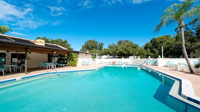 community pool featuring fence and a patio area