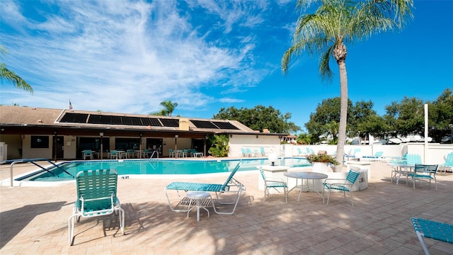 community pool featuring a patio and fence