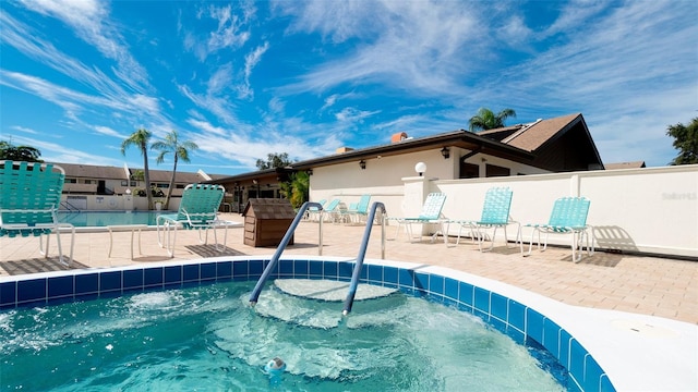 community pool featuring a patio and fence