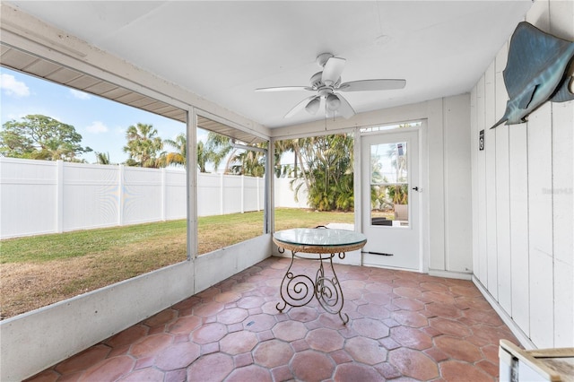 unfurnished sunroom with ceiling fan