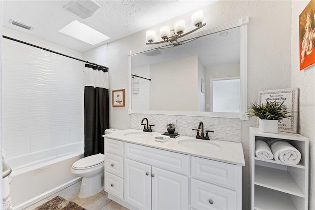 full bathroom with toilet, a skylight, vanity, decorative backsplash, and shower / tub combo with curtain