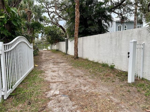 view of yard featuring fence, a gate, and driveway