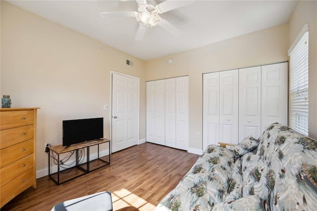 interior space with a ceiling fan, visible vents, baseboards, and wood finished floors