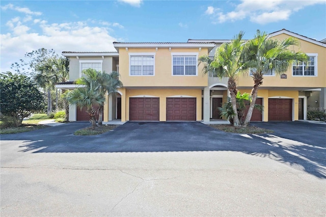 townhome / multi-family property with driveway, an attached garage, and stucco siding