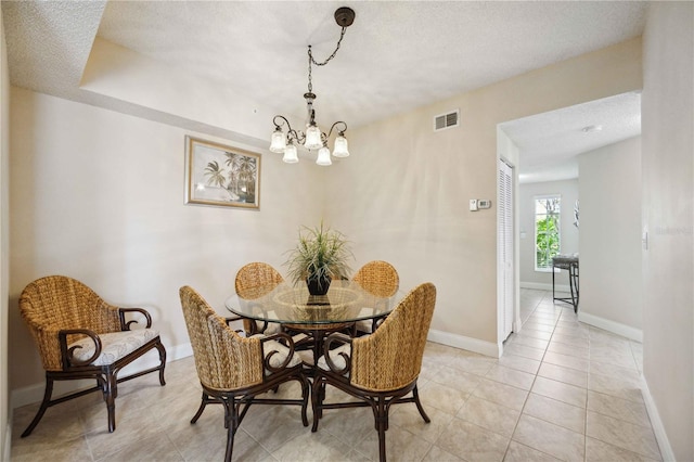 dining area featuring a textured ceiling, visible vents, and baseboards