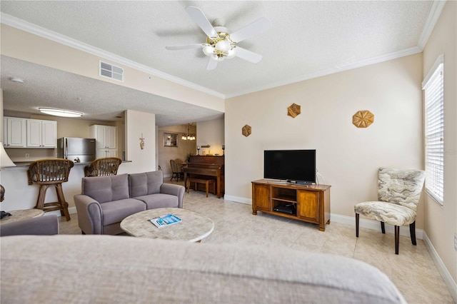 living room featuring a healthy amount of sunlight, visible vents, crown molding, and a textured ceiling